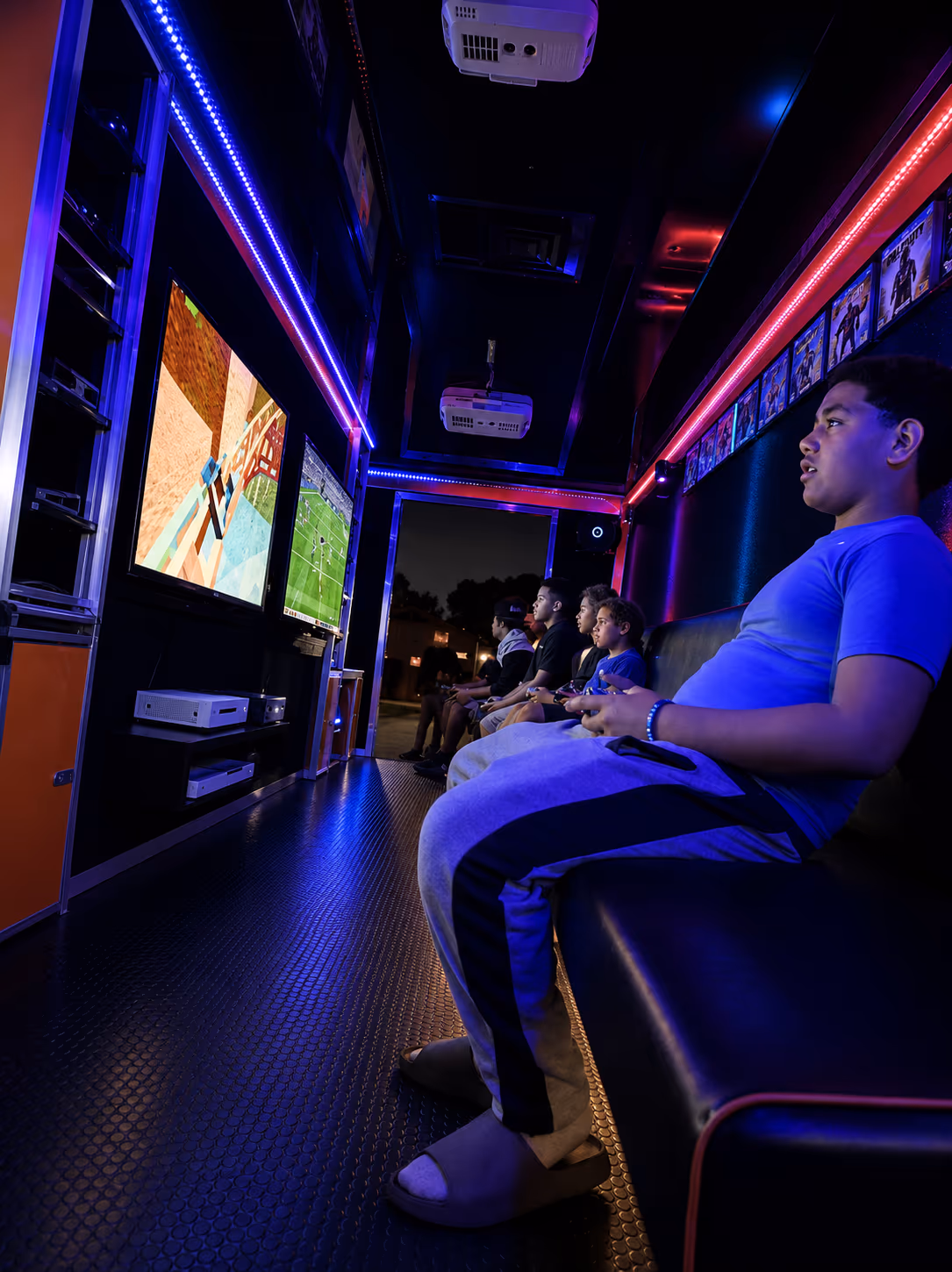 Kids gaming on a big screen inside the Miami video game truck